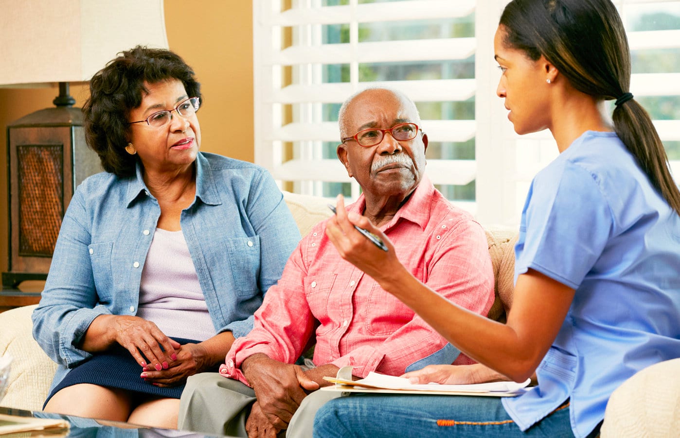 caregiver explaining something to senior couple